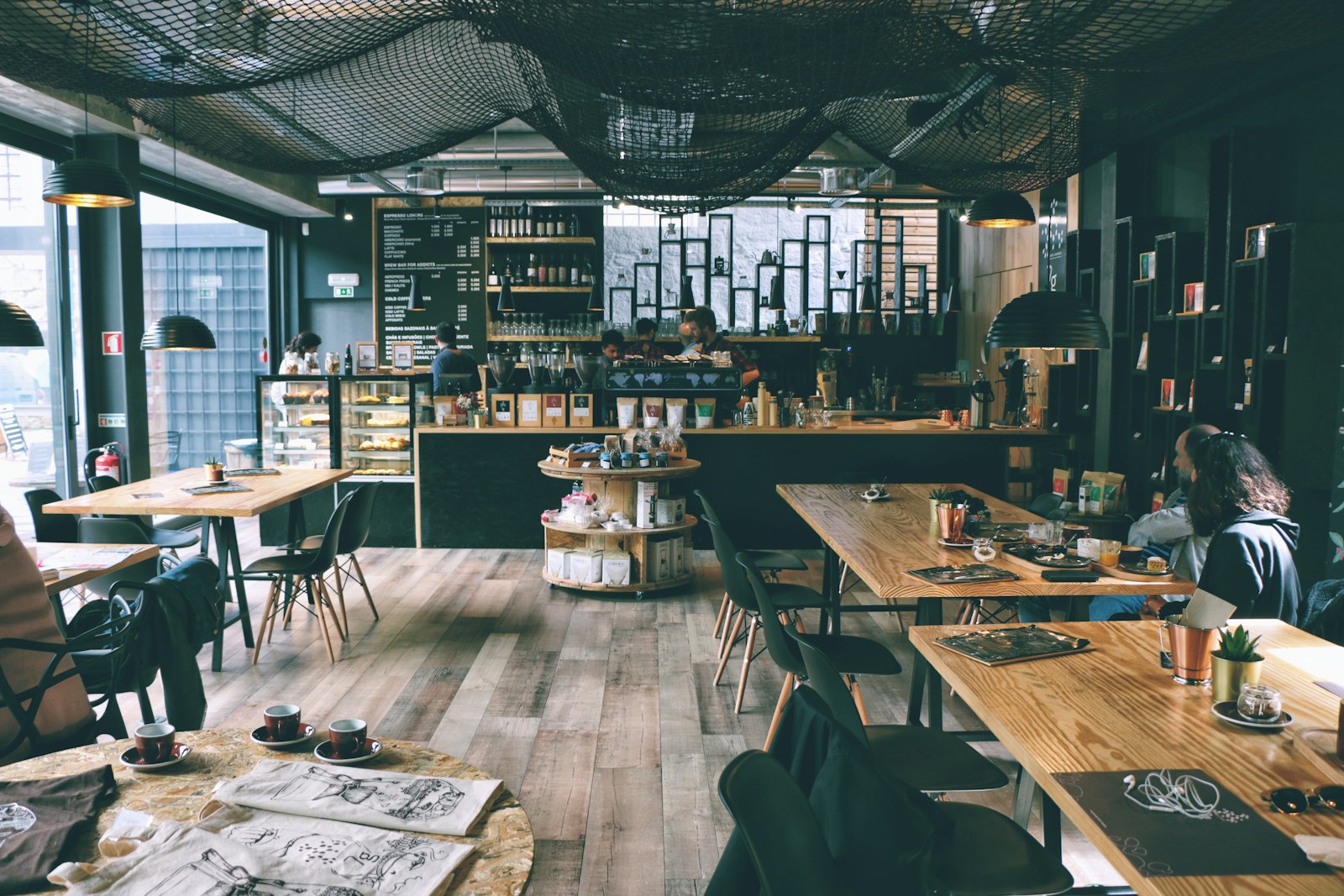 Barista serving coffee across a wooden counter