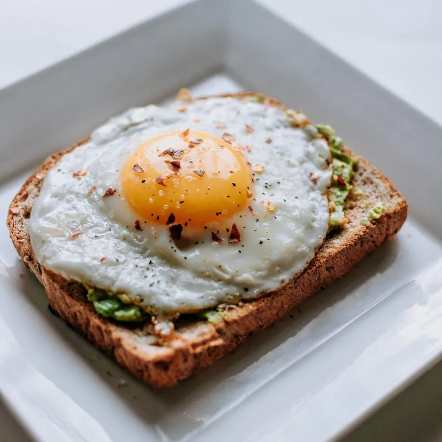 Avocado toast with eggs on a wooden board