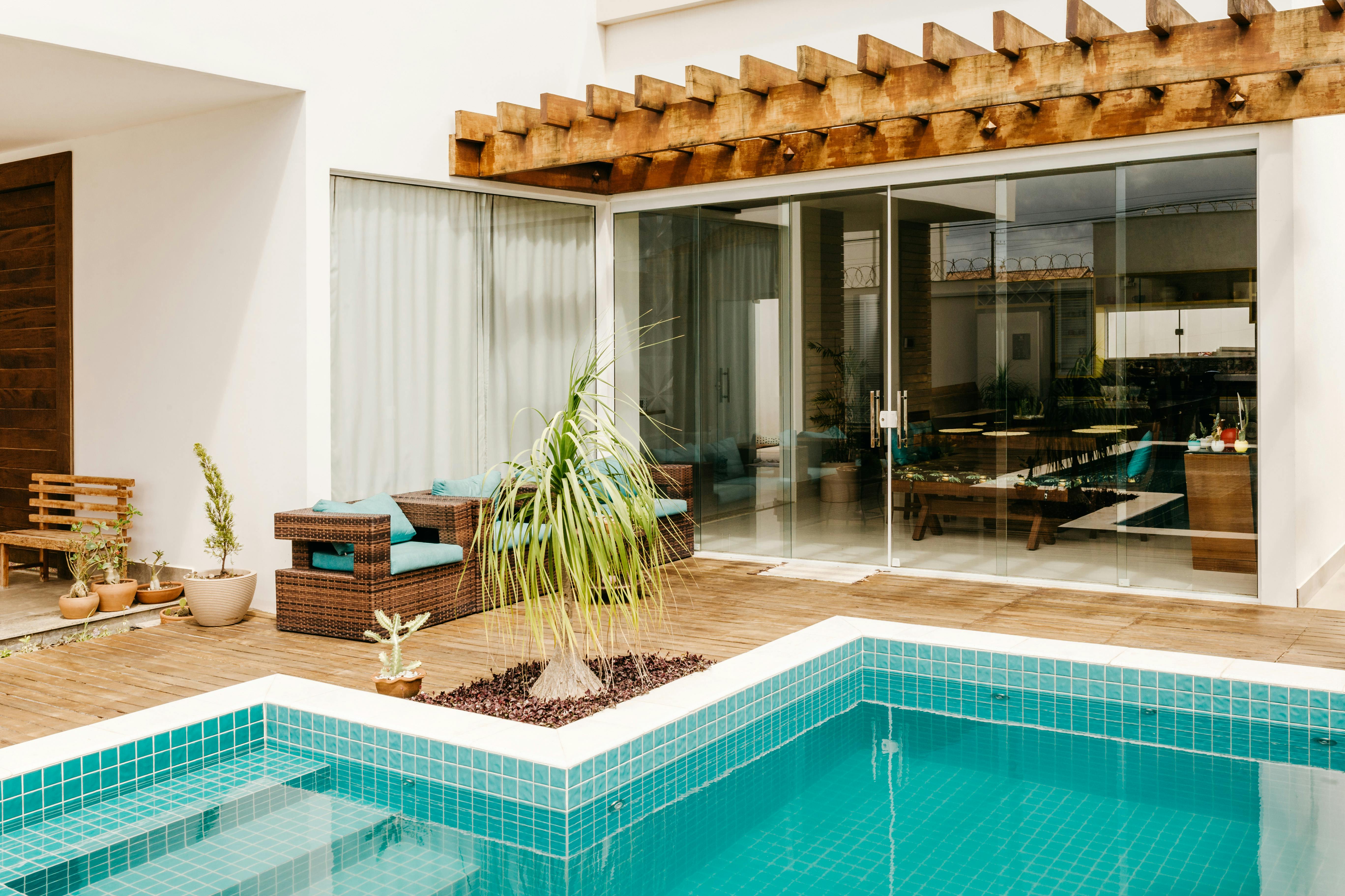Modern poolside courtyard with cedar pergola, tiled pool deck, and refreshed plantings
