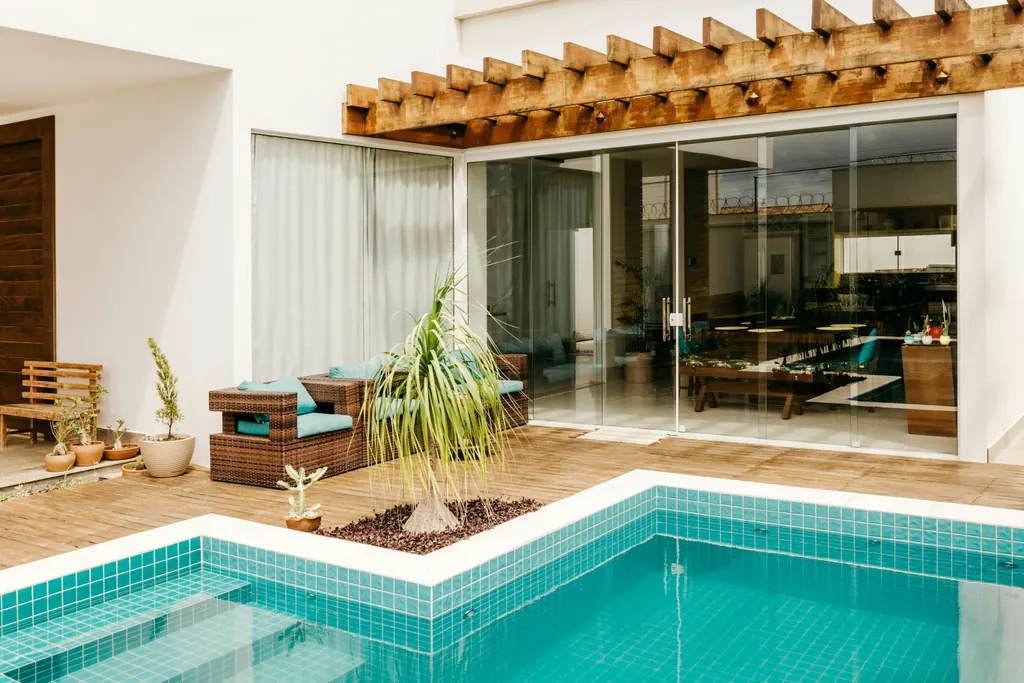 Modern poolside courtyard with cedar pergola, tiled pool deck, and refreshed plantings
