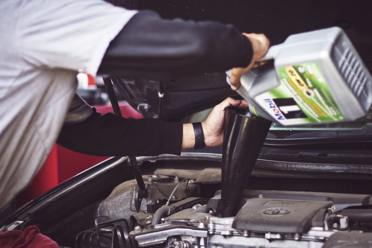 Mechanic adding fresh motor oil during an oil change service