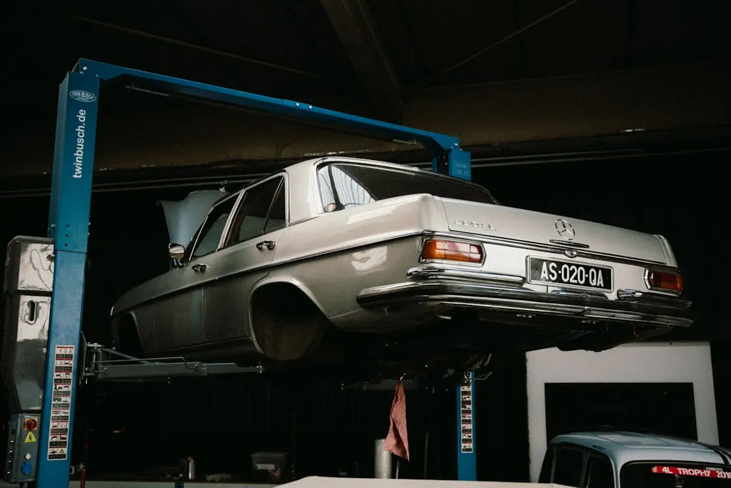 Classic sedan raised on a two-post hydraulic lift